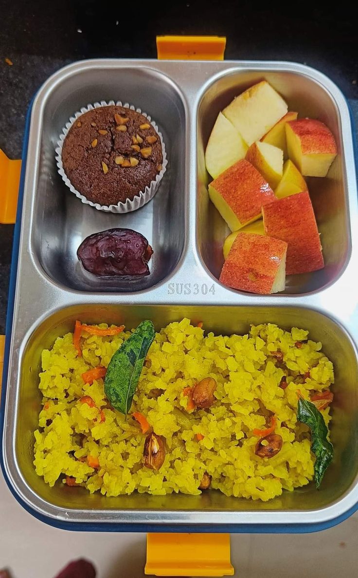 a lunch box with rice, fruit and muffins on the side is ready to be eaten