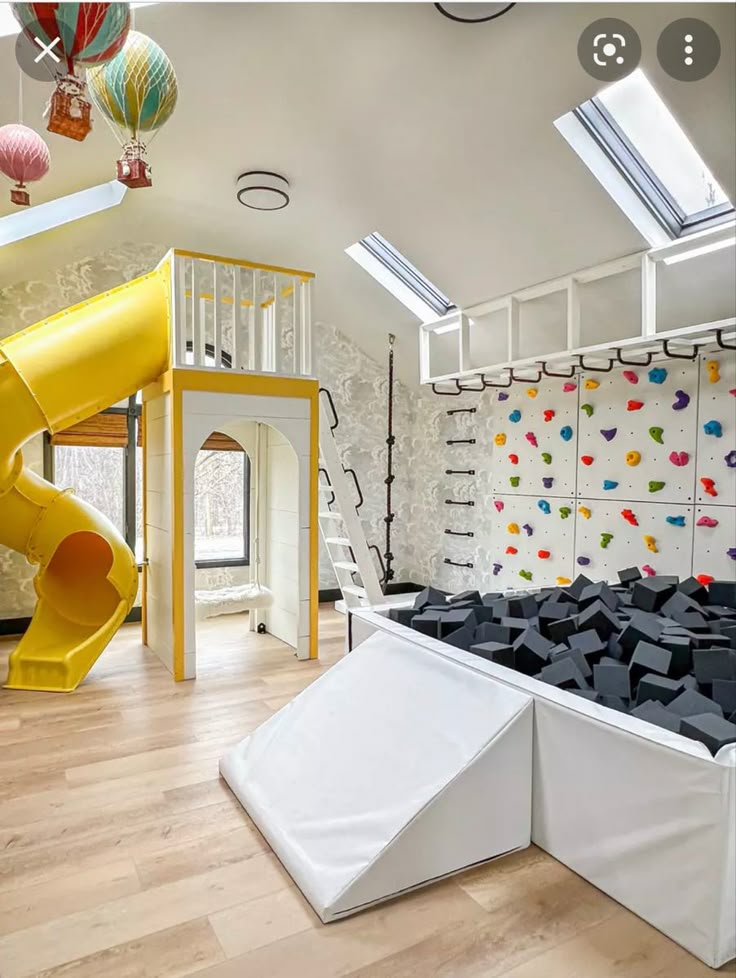 a room with a slide and climbing wall