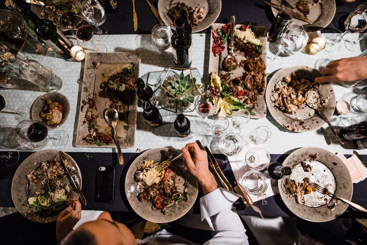 people sitting at a table with plates of food