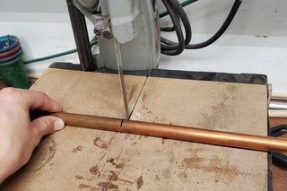 a person using a woodworking tool on a piece of plywood