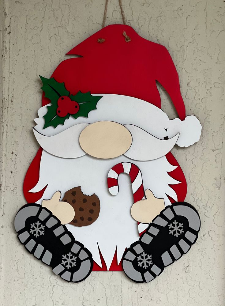 a santa clause sign hanging from the side of a wall with christmas decorations on it