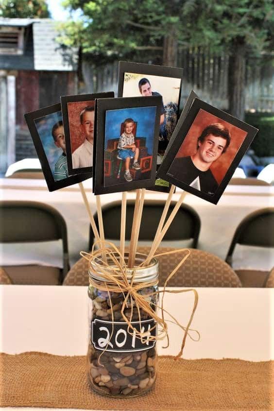 a mason jar filled with pictures on top of a table