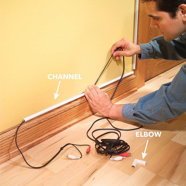 a man is working on the wall with wires and electrical cords in front of him