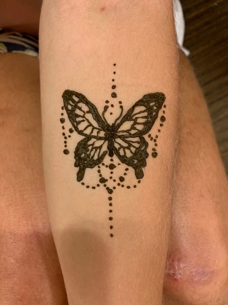 a woman's leg with a tattoo on it that has a butterfly in the middle