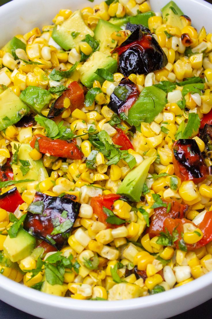 a white bowl filled with corn and vegetables