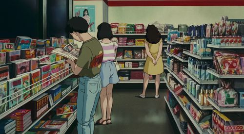 three people in a grocery store looking at items on the shelves and one person reading a book