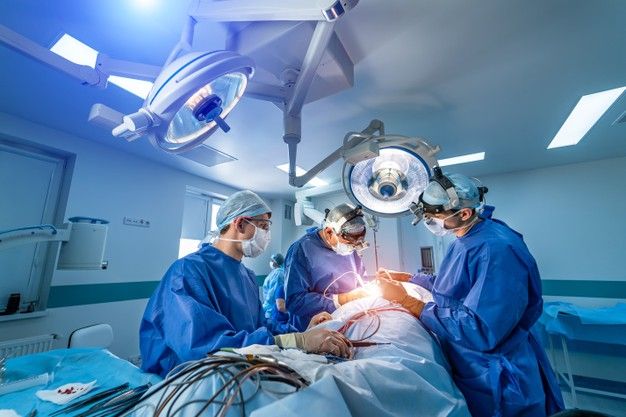 three doctors performing surgery in an operating room