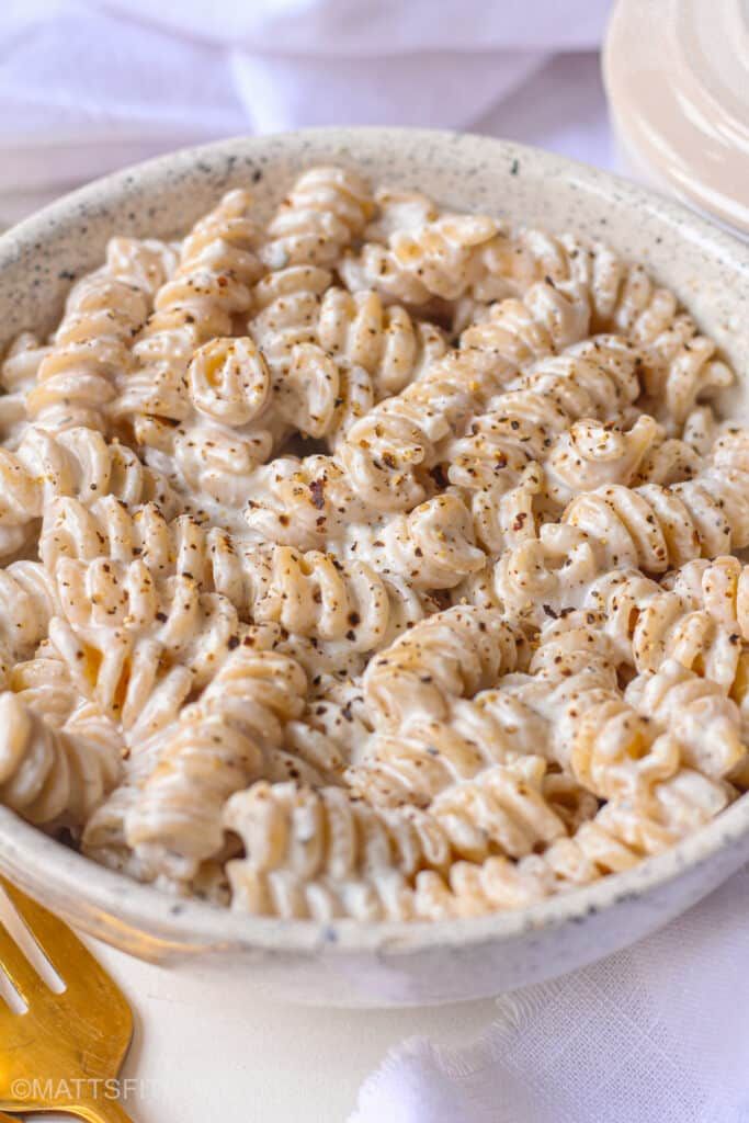 a bowl filled with macaroni and cheese on top of a white table cloth