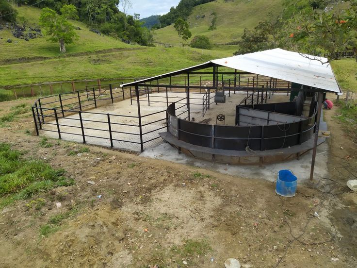 a large metal structure sitting on top of a dirt field