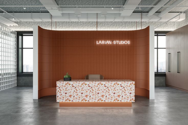 an empty room with a white and orange reception desk in the center, surrounded by glass blocks