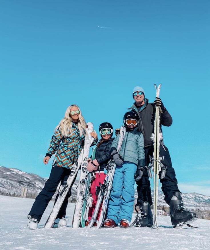 a group of people standing next to each other holding skis