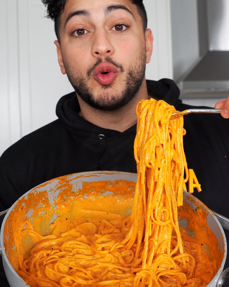 a man is eating spaghetti from a large bowl