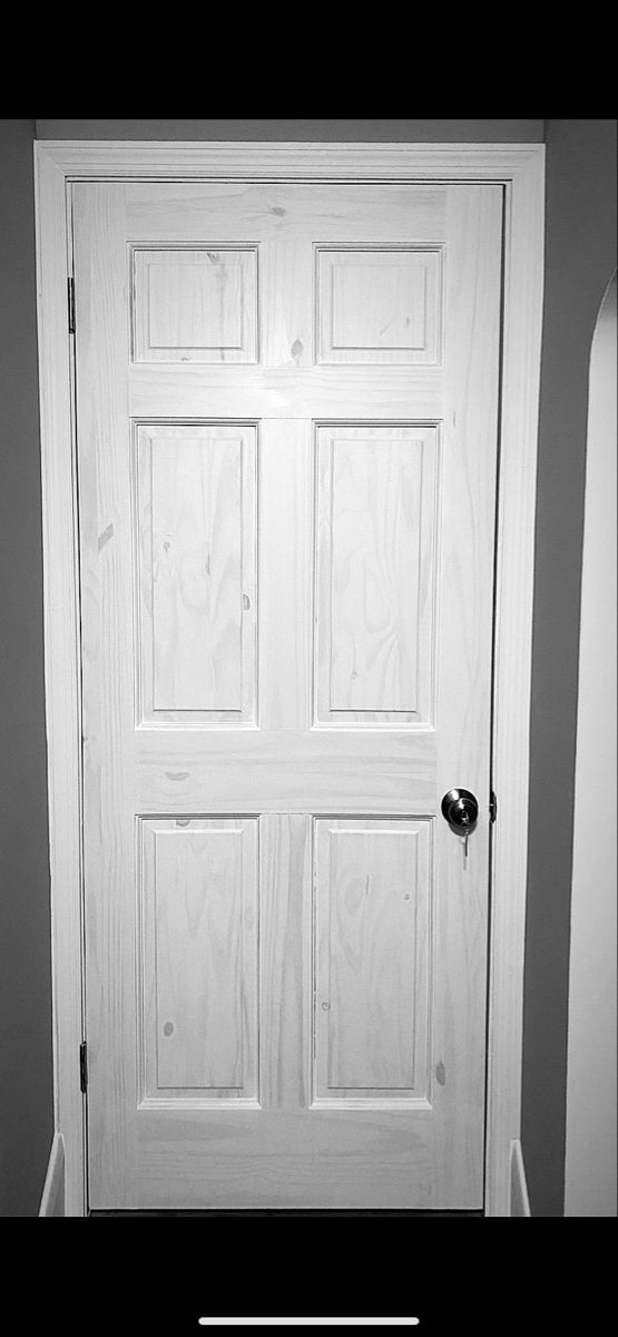 a white door with two black handles in a room