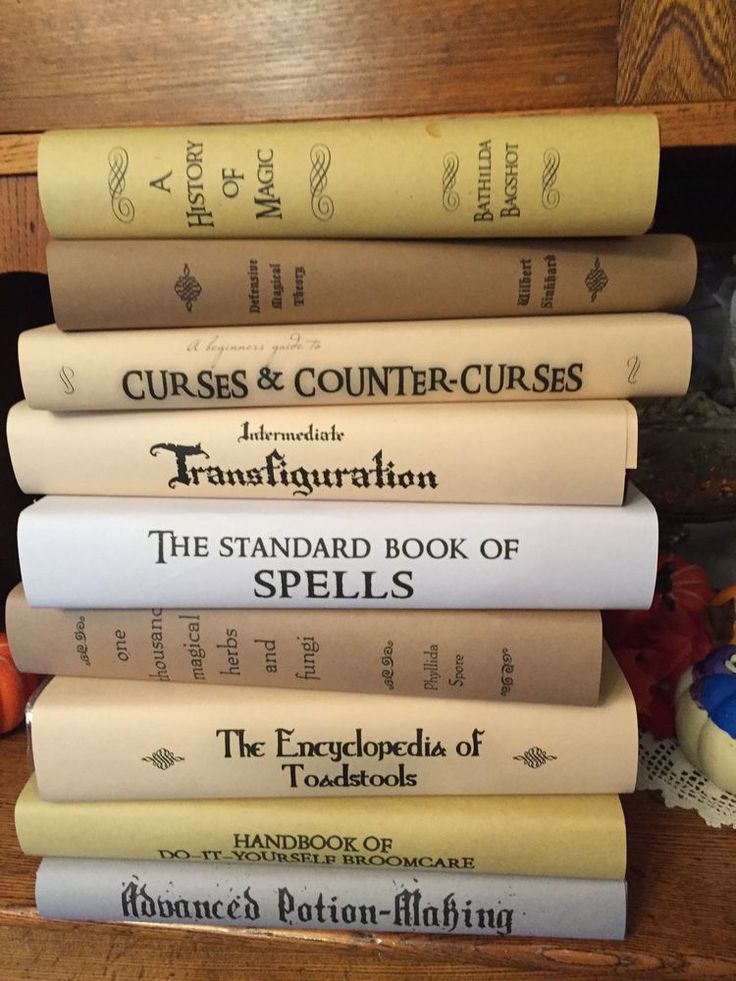 five books stacked on top of each other in front of a wooden shelf with flowers