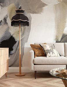 a living room scene with focus on the couch and floor lamp in front of it