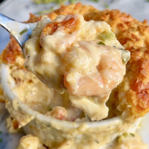 a spoon full of chicken pot pie casserole on top of a white plate