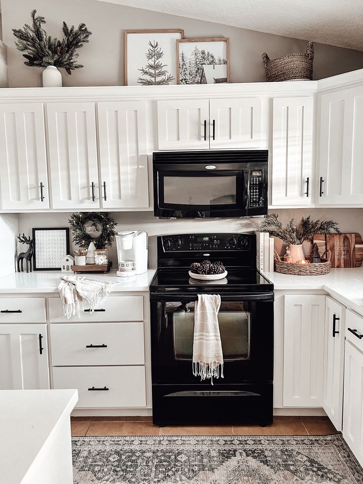 a black stove top oven sitting inside of a kitchen next to white cabinets and drawers