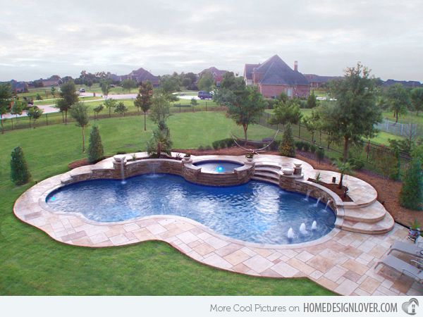 a backyard with a swimming pool surrounded by landscaping