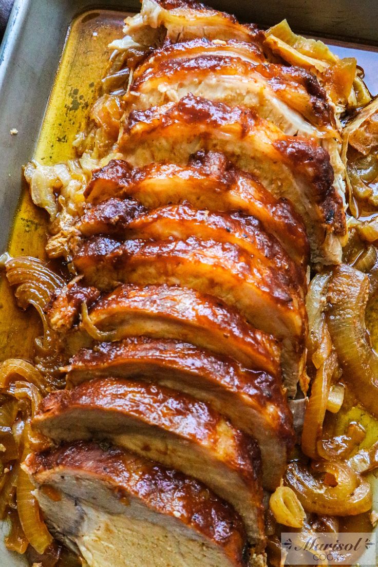 sliced pork roast with onions and mushrooms on a baking sheet