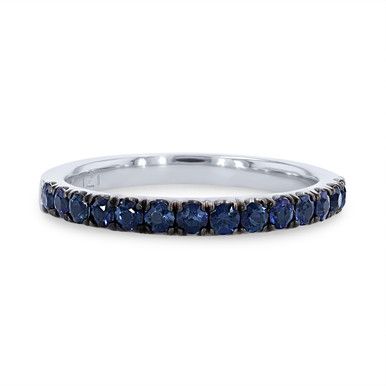 a white gold ring with blue sapphire stones on the sides and a thin band in the middle