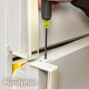 a person using a screwdriver to fix a refrigerator