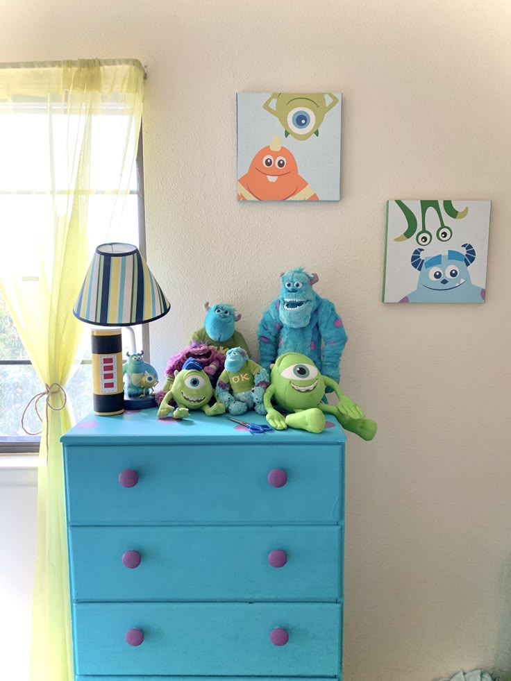 a blue dresser with stuffed animals on it