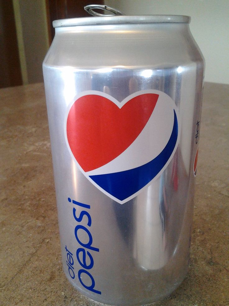 a can of pepsi on a table with a heart shaped sticker in the top