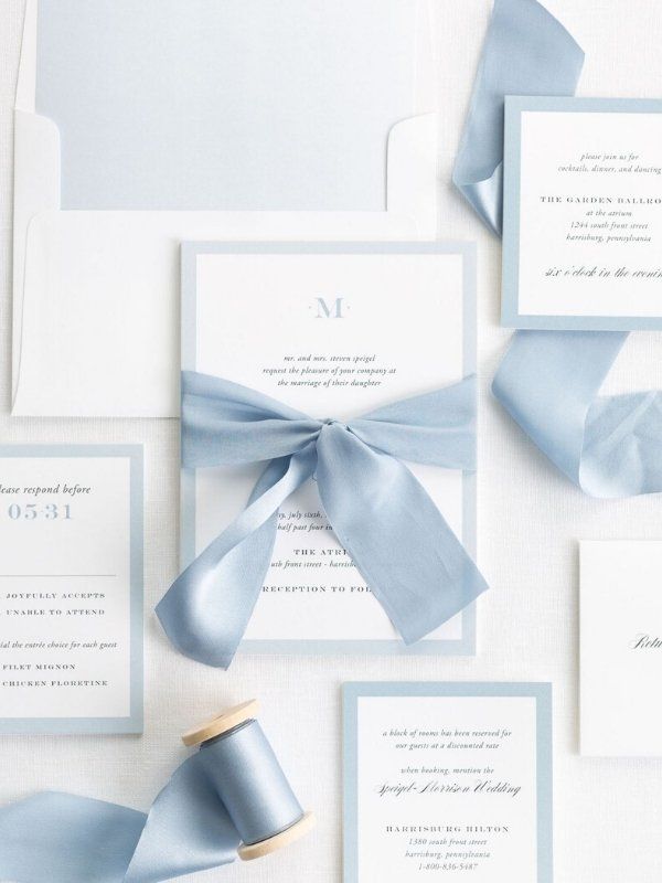 the wedding stationery is laid out on top of each other with ribbons and bows