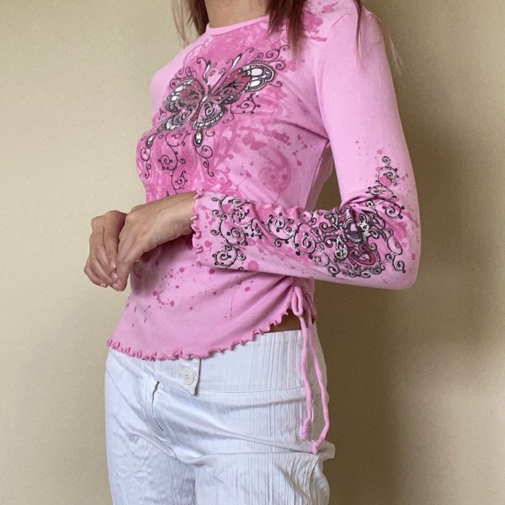 Be a y2k butterfly princess with this fitter pink top with ruffled edges and ruched details. Material: Polyester and Spandex Small: Bust: 80-84 Waist: 68 Length: 52 Sleeve: 56 Medium: Bust: 84-88 Waist: 72 Length: 53 Sleeve: 57 Large: Bust: 88-92 Waist: 76 Length: 54 Sleeve: 58 Pink Y2k Style Tops For Spring, Pink Y2k Tops For Spring, Pink Fitted Y2k Style Top, Fitted Barbiecore Tops, Trendy Pink Butterfly Print Tops, Pink Y2k Style Party Tops, Fitted Long Sleeve Tops With Butterfly Print, Pink 90s Style Spring Tops, Fitted Butterfly Print Tops For Spring