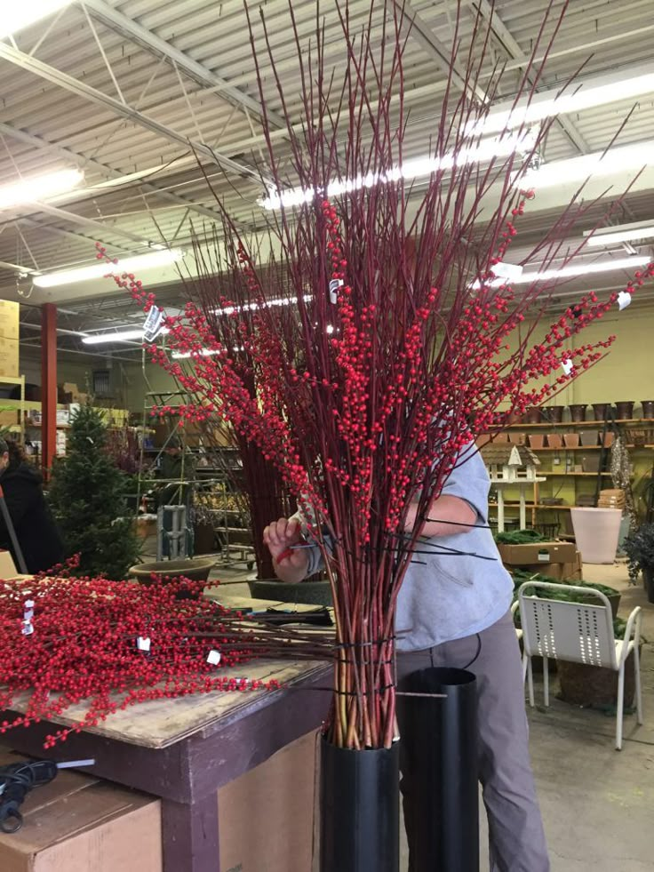 a woman arranging red berries in a store