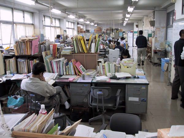 an office filled with lots of books and people