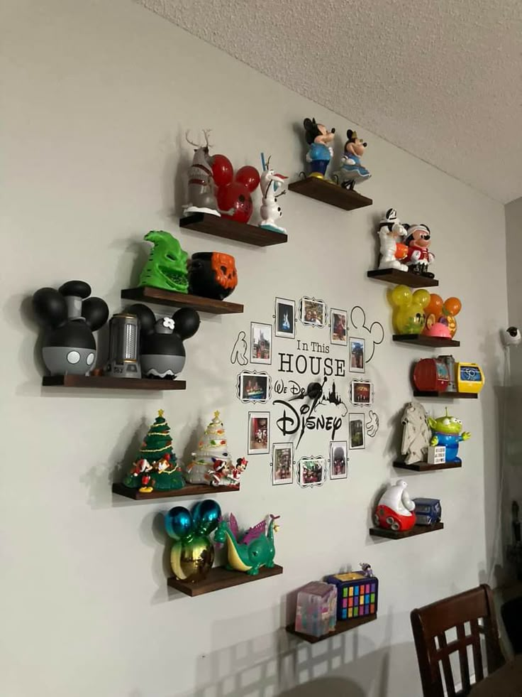 the wall is decorated with many different disney figurines and mickey mouse head decorations