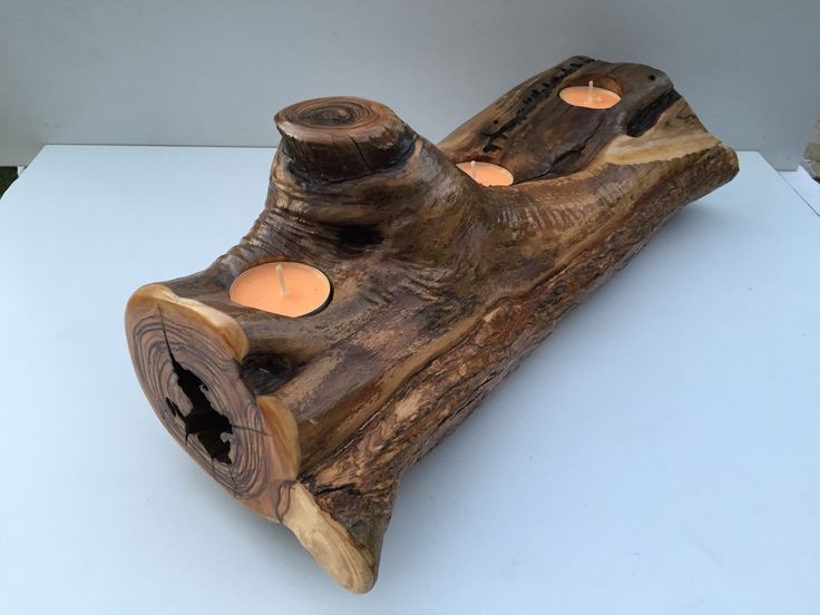 a candle holder made out of wood with candles in the shape of a boat on it