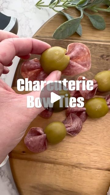 someone is cutting up some olives on a board with the words charcuterie bowties