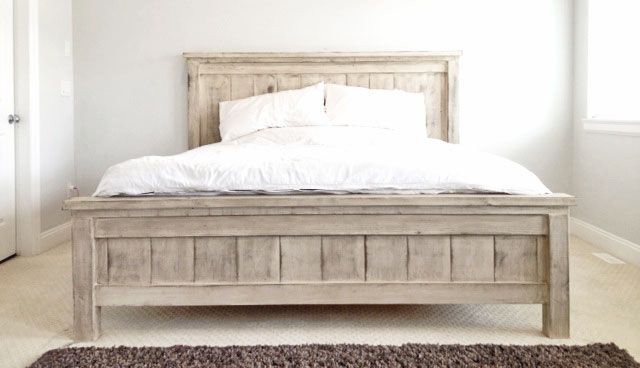 a white bed sitting next to a window in a bedroom on top of a rug