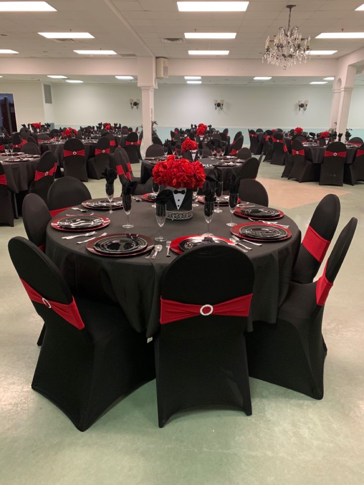 an empty banquet room with black and red decor