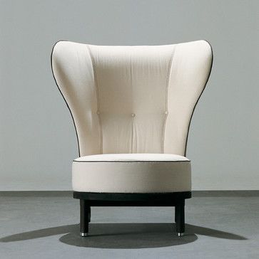 a white chair sitting on top of a gray floor next to a black and white wall