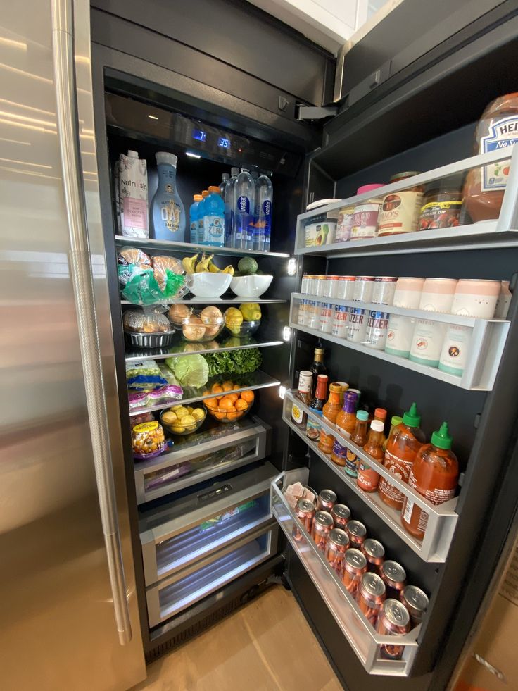 an open refrigerator filled with lots of different types of food and condiments on shelves