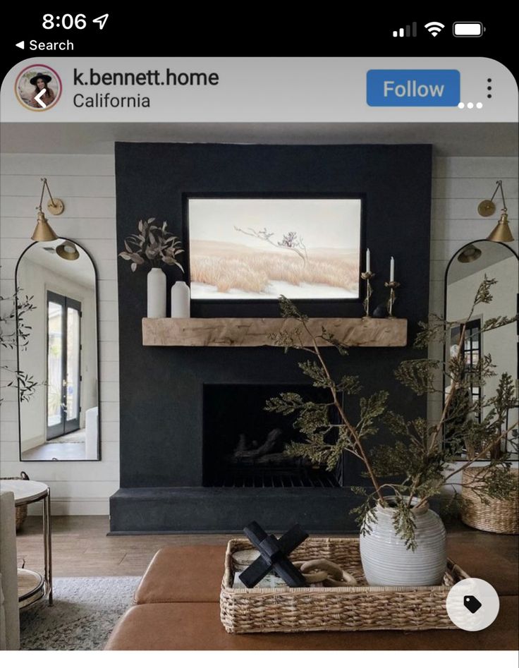 the living room is decorated in black and white with greenery on the coffee table