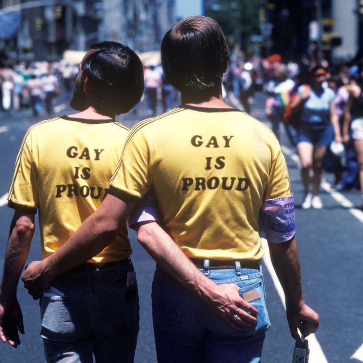 two people in yellow shirts are walking down the street with their backs to each other