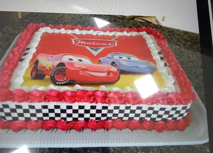 a birthday cake with cars on it sitting on a counter