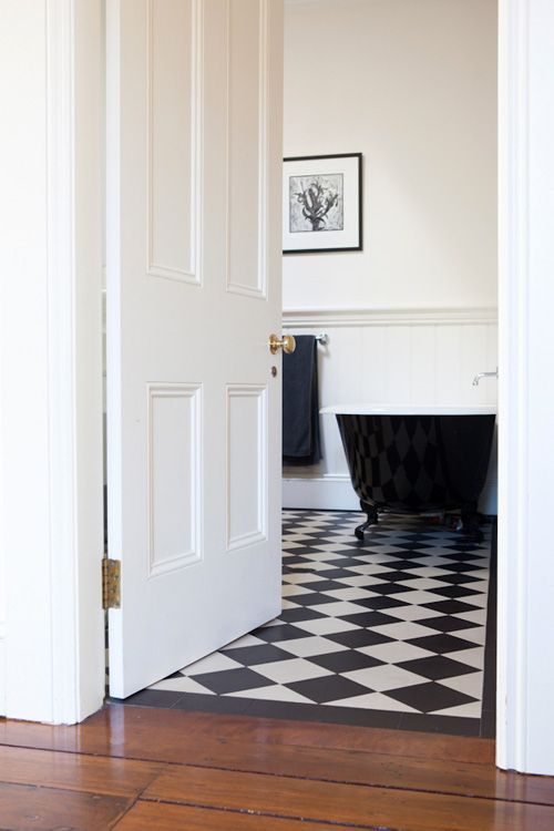 an open door leading to a bathroom with a black and white checkered floor