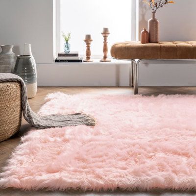 a living room with a pink rug on the floor