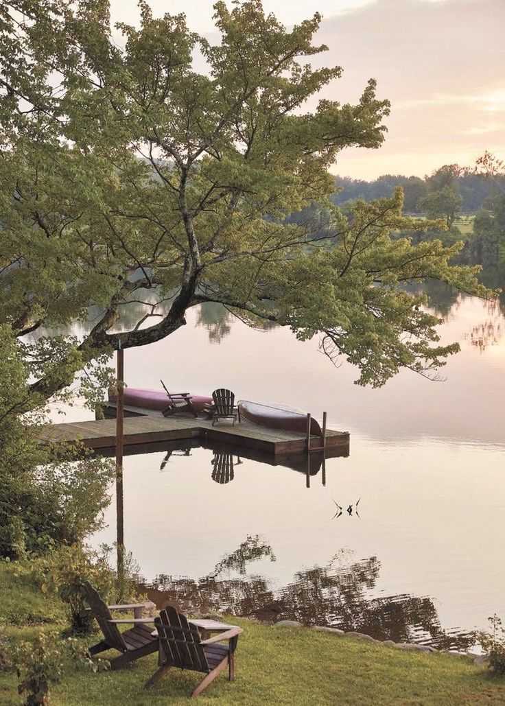 there is a boat tied to the dock by the water's edge at sunset