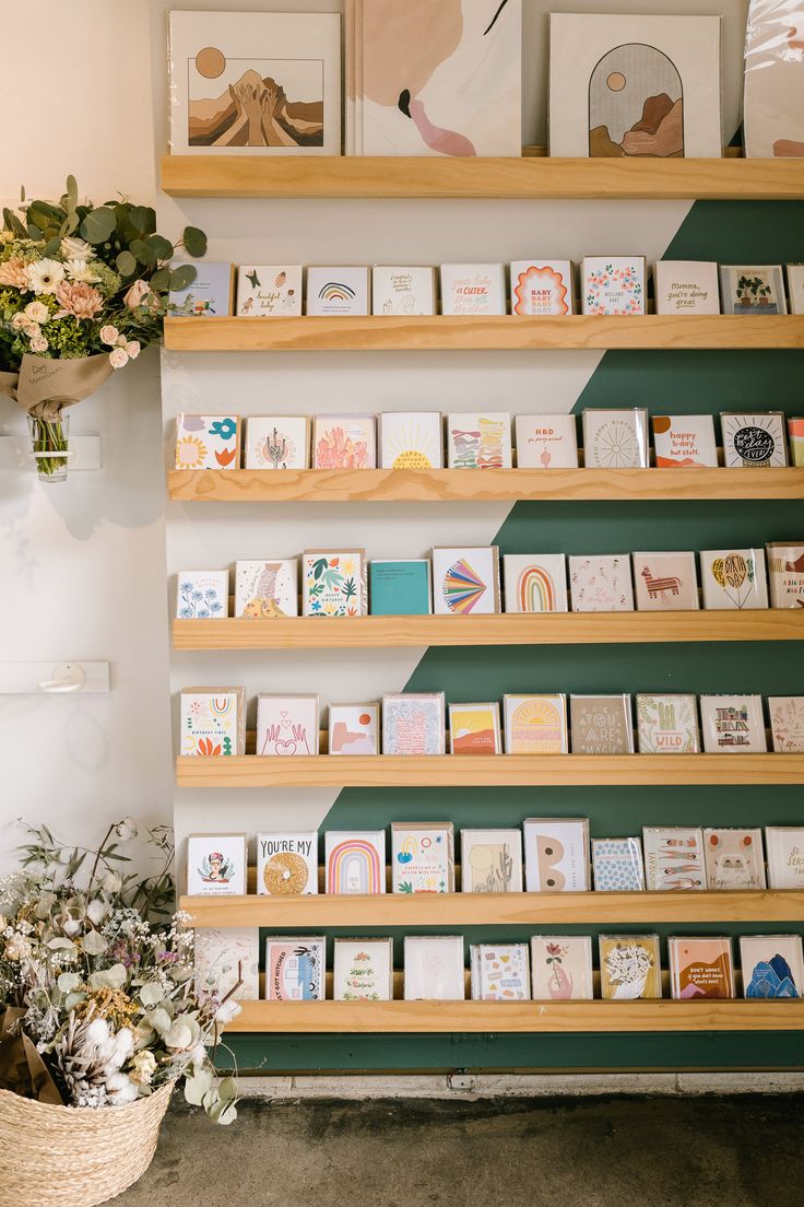 there are many cards on the shelves in this room and one is holding some flowers