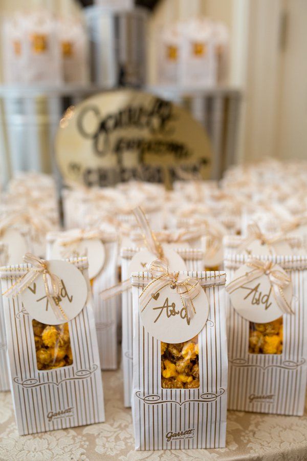 there are many small boxes with food in them on the table at this wedding reception