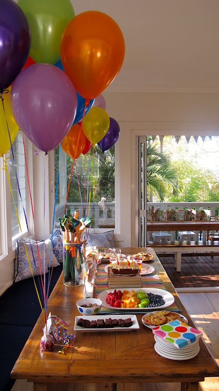 a table filled with lots of food and balloons