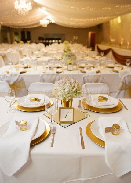 the tables are set with white linens and gold place settings