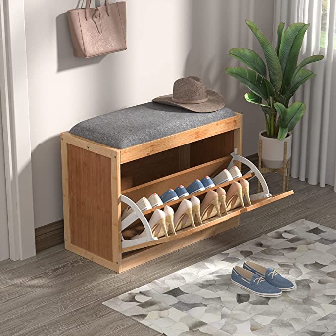 a wooden shoe rack filled with shoes next to a potted plant