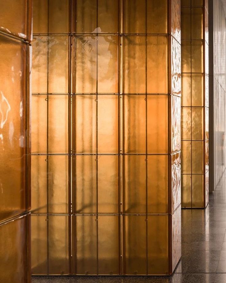 an empty hallway with wooden panels and tiled flooring on both sides, in front of a glass wall